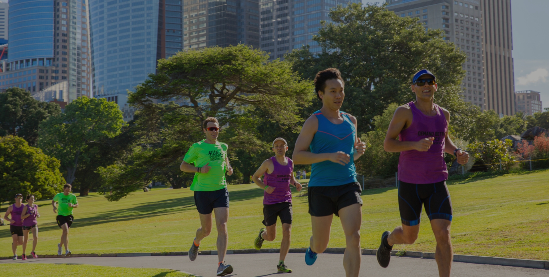 Runners in a park with city skyline